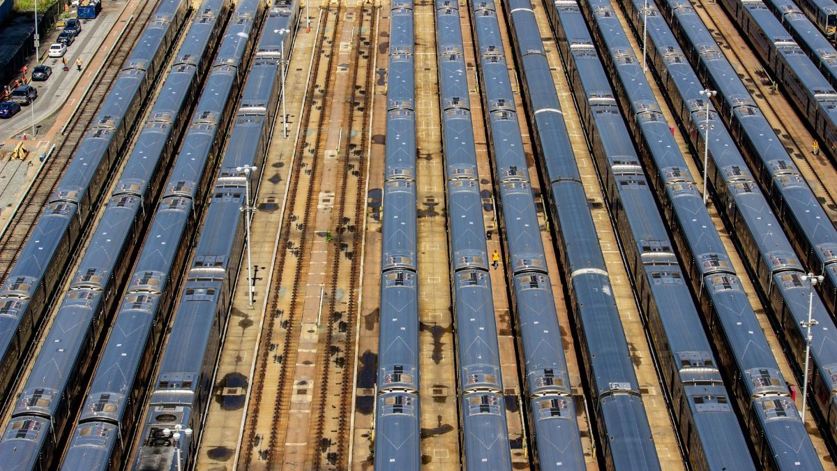 Aerial view of a busy train yard in New York City showcasing multiple trains parked in parallel tracks.