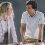 Two colleagues discussing project plans in a modern office environment with a collaborative atmosphere.