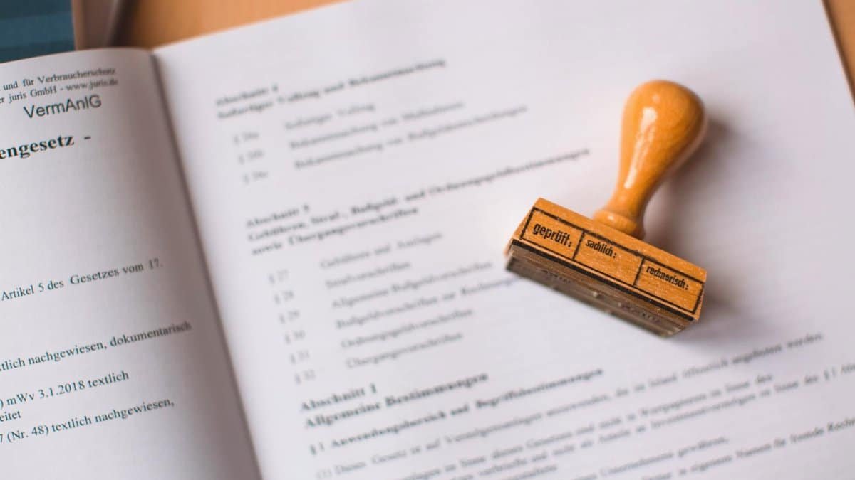 Close-up of a legal document with a wooden stamp placed on top, highlighting verification.