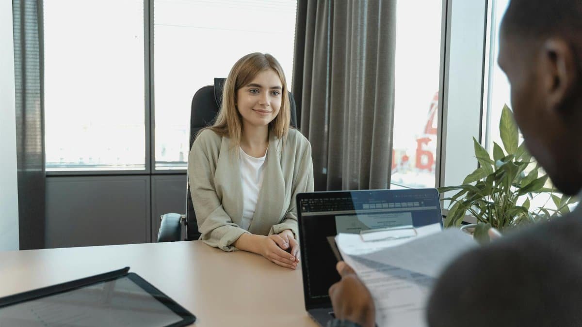 Young woman sitting confidently in a modern office for a job interview.