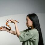 A woman confronting her fear by holding a snake, symbolizing overcoming anxiety.