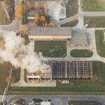 Aerial shot of an industrial area with visible smoke emissions in Poznań, Poland.