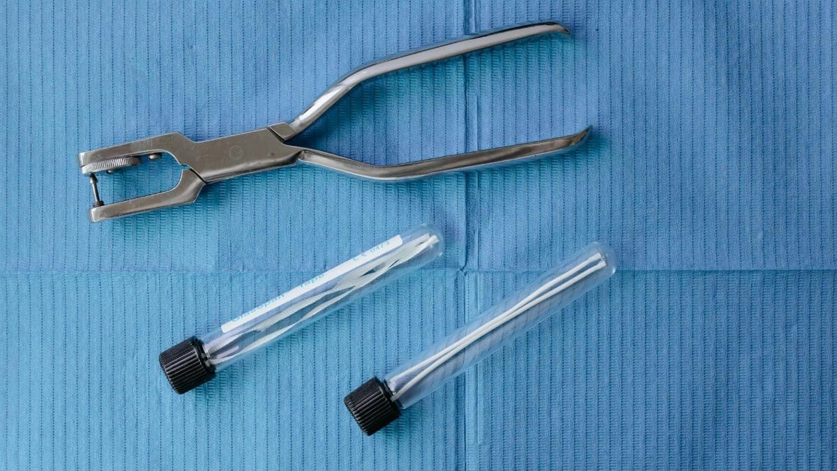 Close-up of dental tools and test tubes on a blue surface, highlighting modern medical equipment.