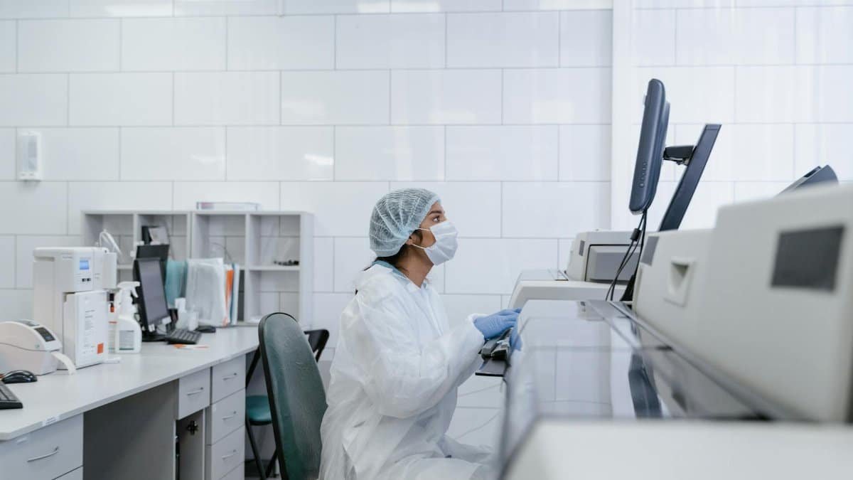 Scientist wearing protective gear conducts research in a modern lab setting.