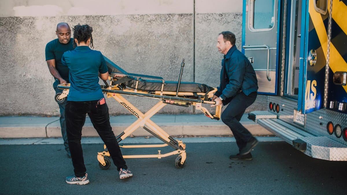 Paramedics load a stretcher into an ambulance, showcasing emergency response in action.