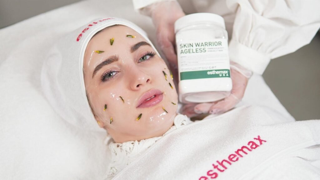 Woman receiving a skincare treatment holds Esthemax product. Spa and beauty setting.