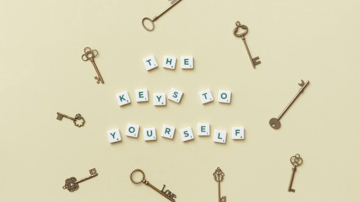 Motivational message with antique keys and letter blocks on yellow background.