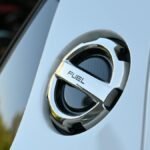 Detailed image of a chrome fuel cap on a luxury vehicle, highlighting sleek design.