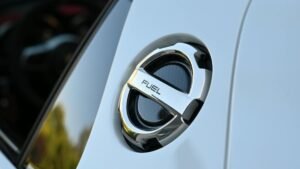 Detailed image of a chrome fuel cap on a luxury vehicle, highlighting sleek design.