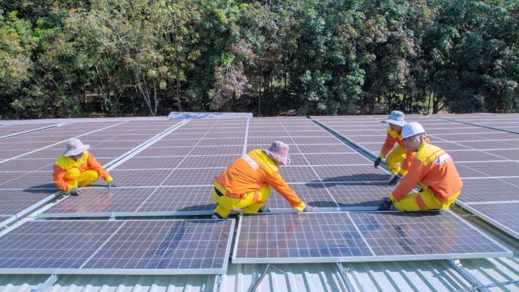 Team of workers installing solar panels on a sunny day, promoting renewable energy and sustainability.