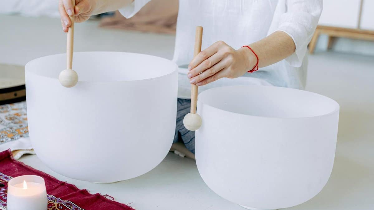 Close-up of hands playing crystal singing bowls for sound healing and meditation.