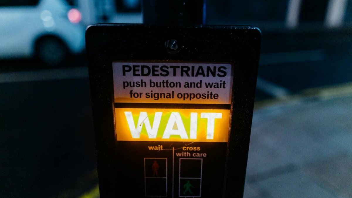 Close-up of an illuminated pedestrian crossing signal on a city street at night.