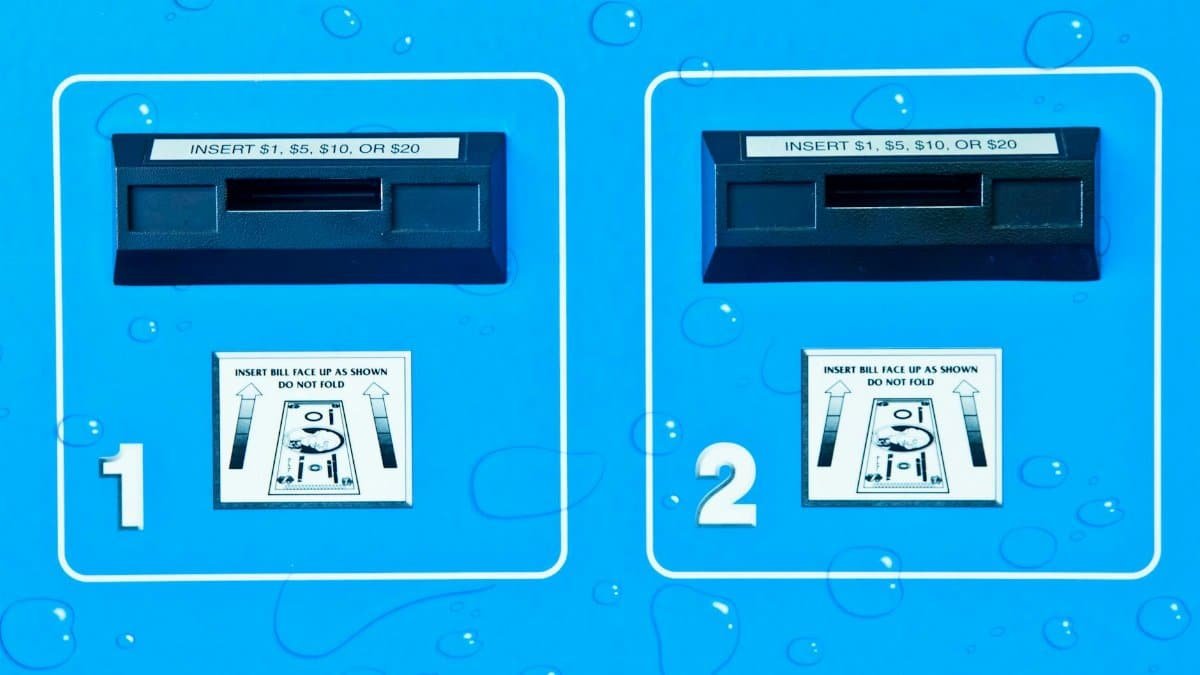 Close-up view of vending machine bill acceptors with payment instructions on a blue background.