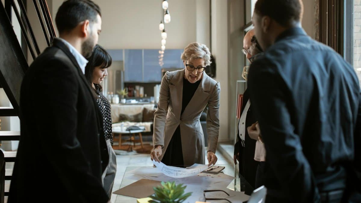 Business team engaged in a collaborative meeting around a workspace with documents.