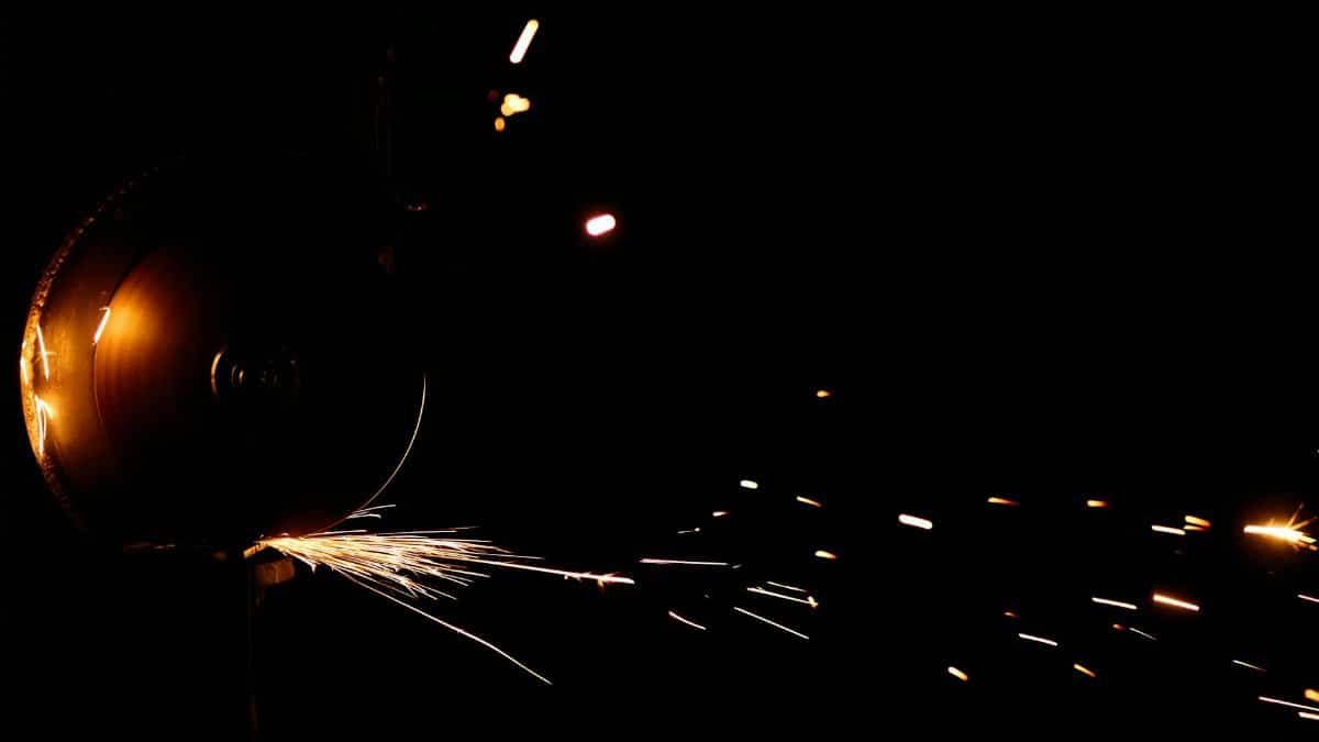 Sparks flying from an angle grinder against a dark background, showcasing vivid motion.