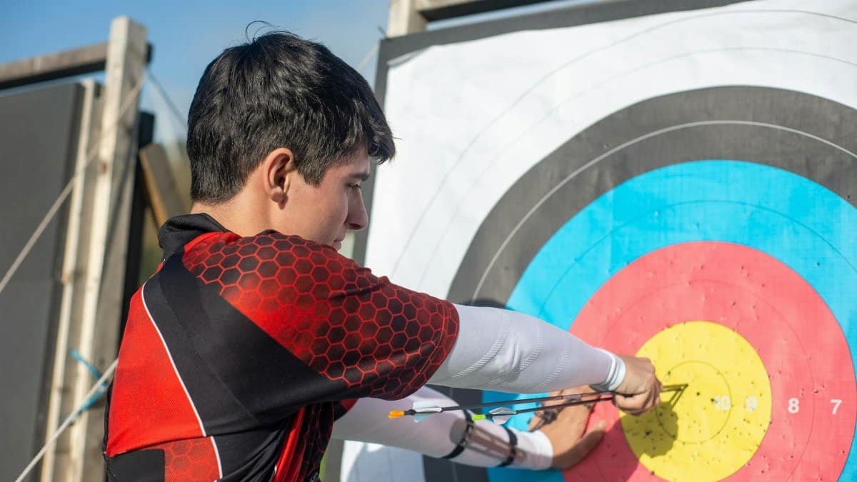 Focused young archer hitting the bullseye with precision outdoors.
