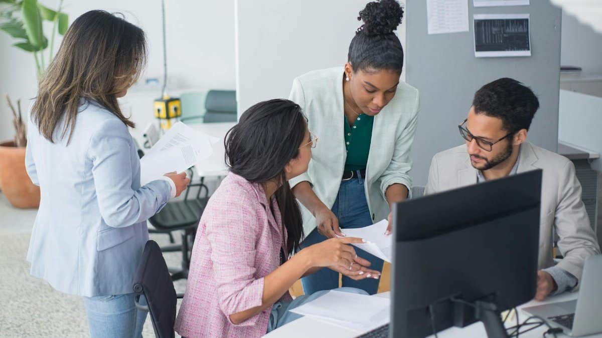 A diverse team engaged in a lively discussion in a modern office setting, fostering collaboration and teamwork.
