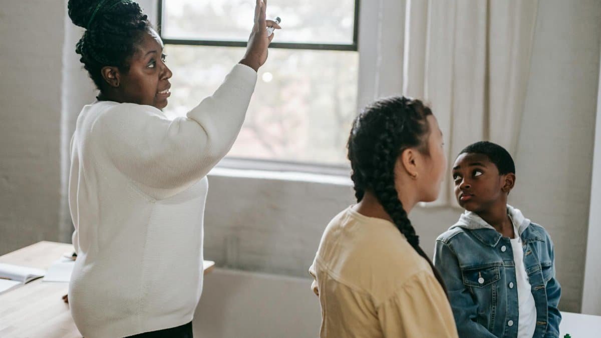 Teacher and students engaged in a learning session indoors with focus and interaction.