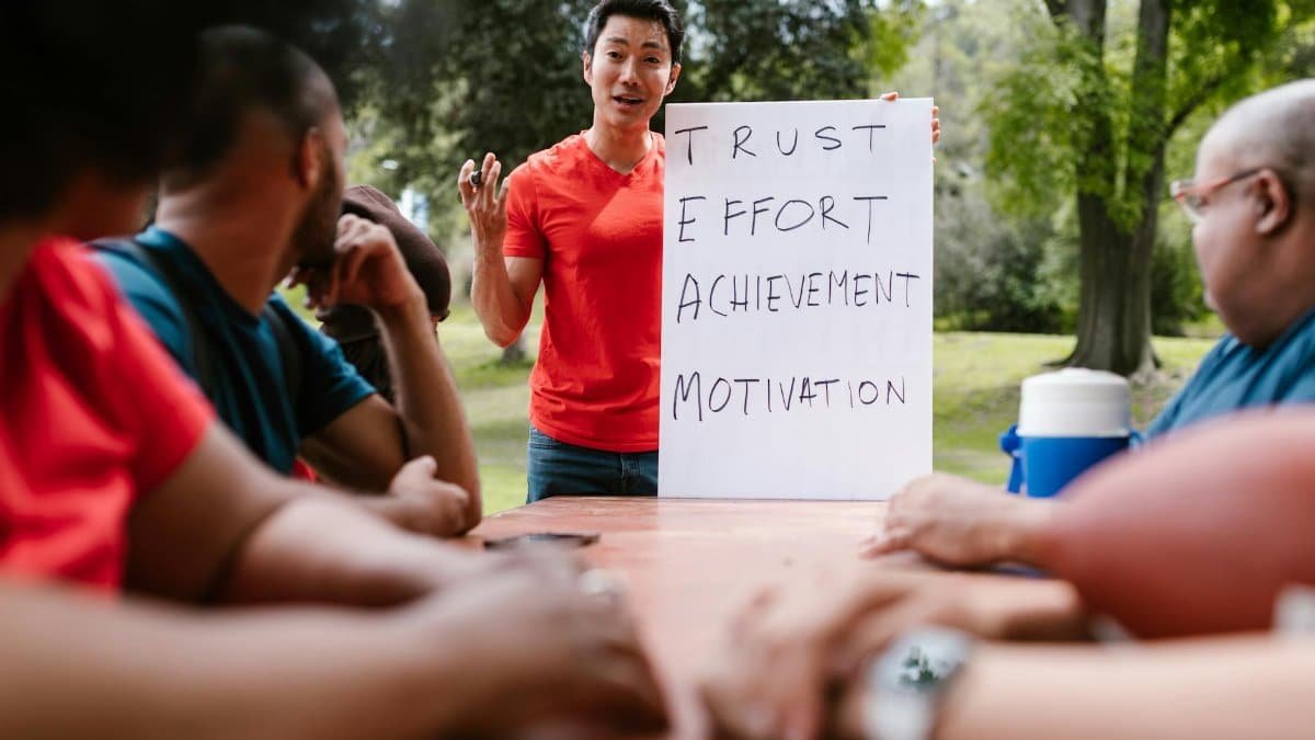 Diverse group engaged in outdoor team building, highlighting trust and effort.