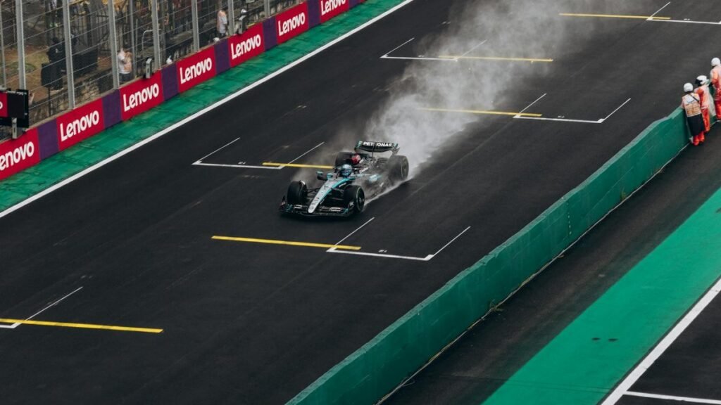 Formula 1 car speeding on wet track during race. High-energy motorsport action.