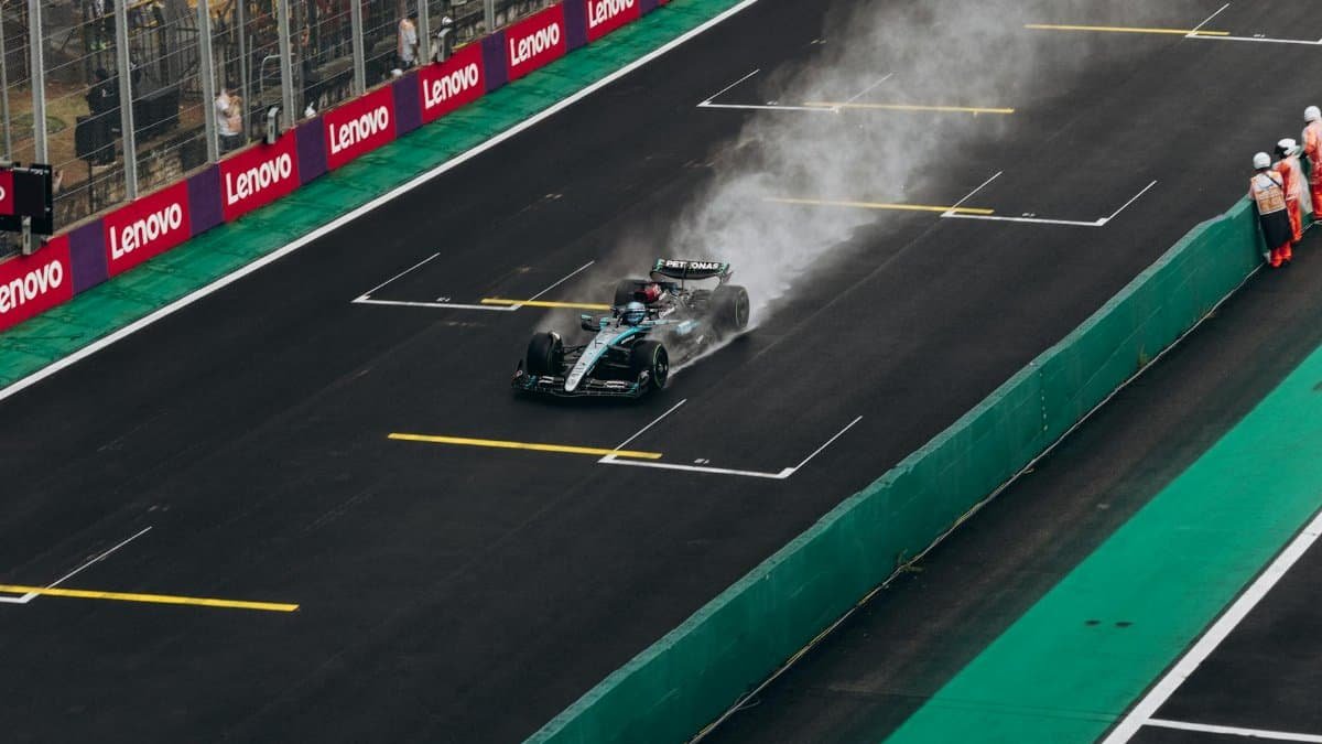 Formula 1 car speeding on wet track during race. High-energy motorsport action.