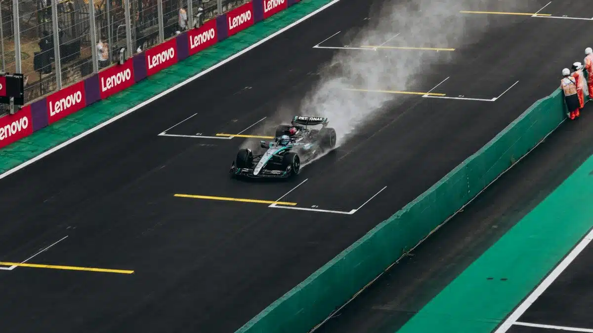 Formula 1 car speeding on wet track during race. High-energy motorsport action.