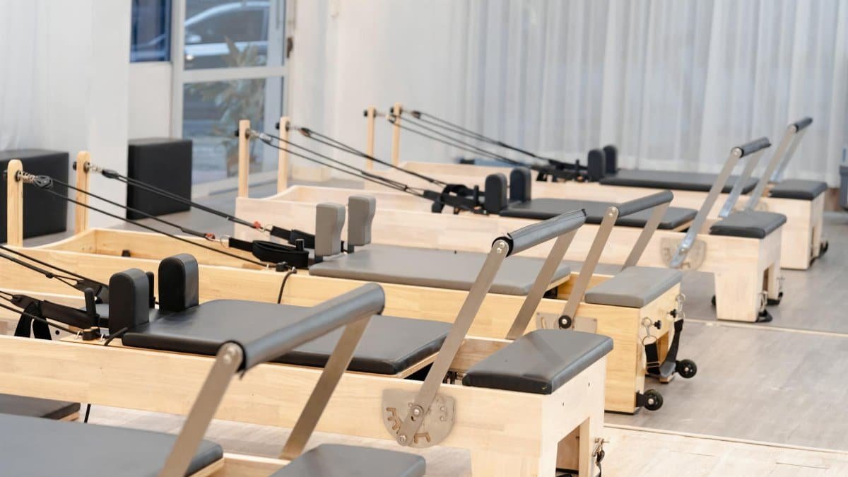 A contemporary Pilates studio equipped with multiple wooden reformers for fitness training.
