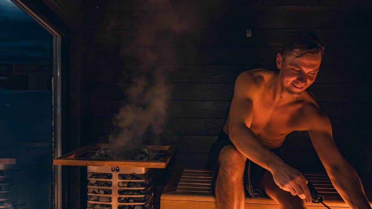 A man enjoying a warm and relaxing sauna session, embracing Nordic design.
