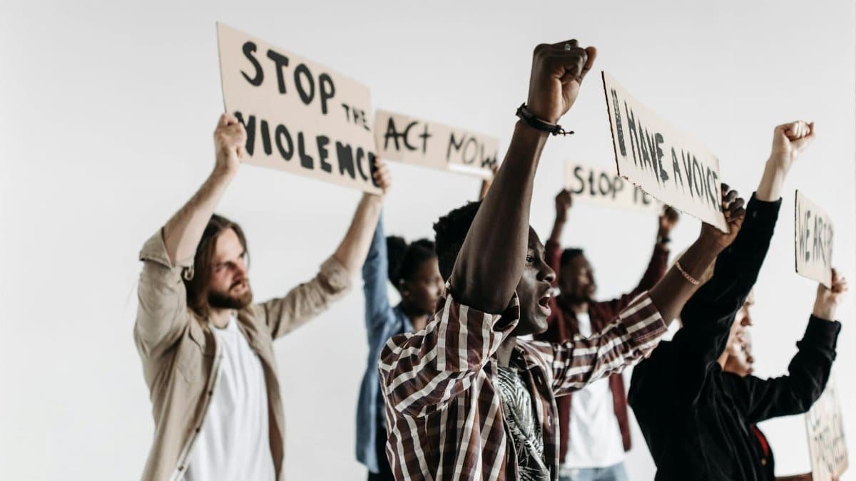 A diverse group of adults passionately protesting against violence with signs.