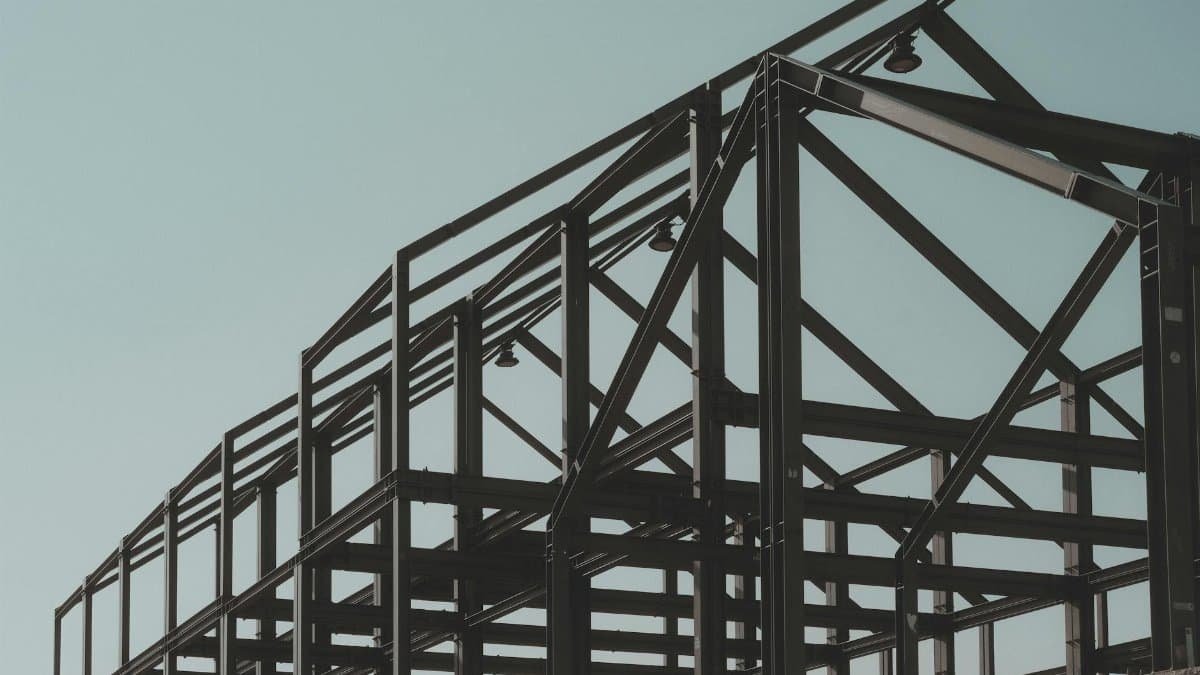 Modern steel framework structure under clear sky, showcasing architectural design.