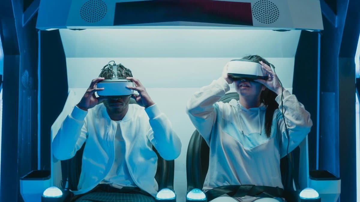 Two adults engaged in a virtual reality experience using VR headsets in a futuristic setting.