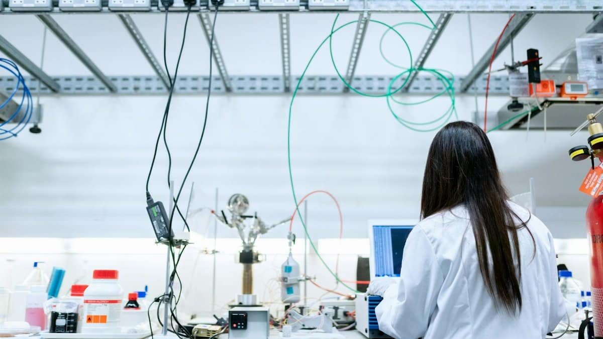 A female scientist conducting research in a contemporary laboratory full of equipment.