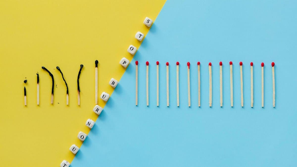 Illustration of burnout concept with burned matches and letter cubes spelling 'Stop Burnout.'