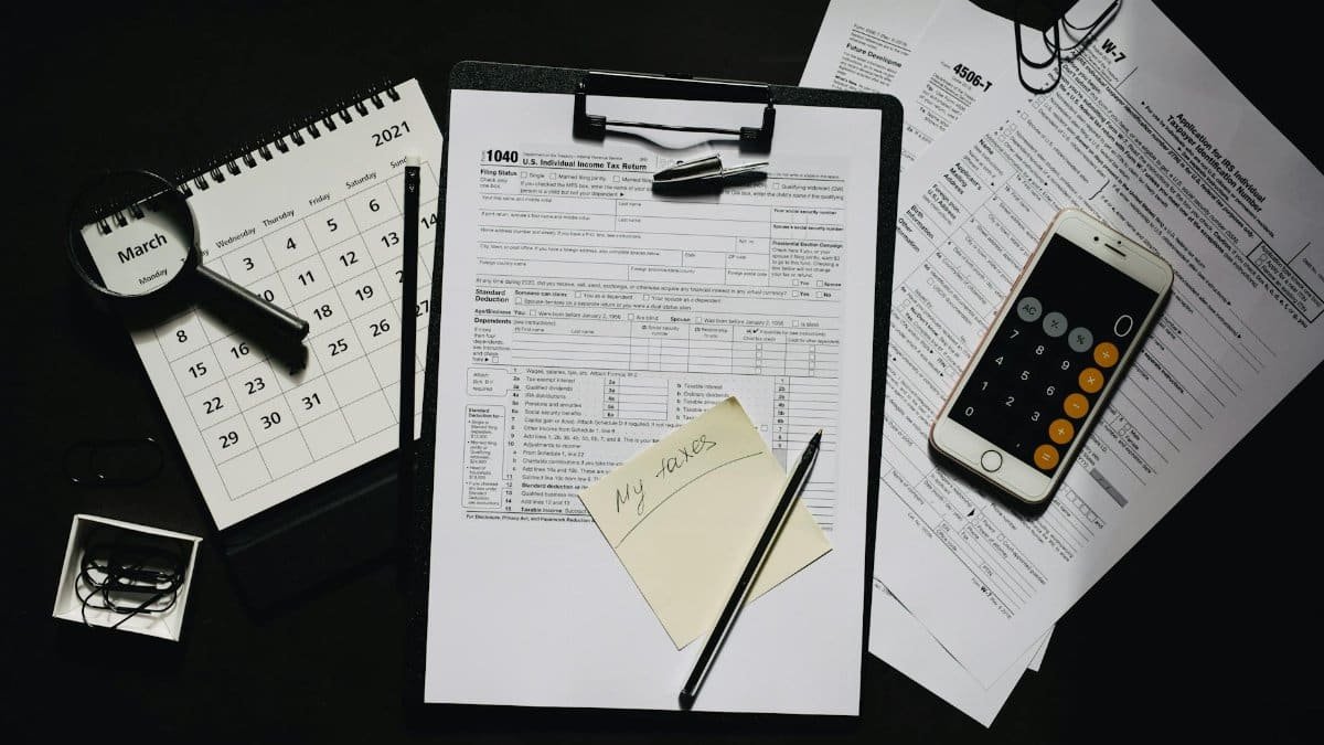 High angle view of tax forms, calculator, calendar, and pen for financial planning.