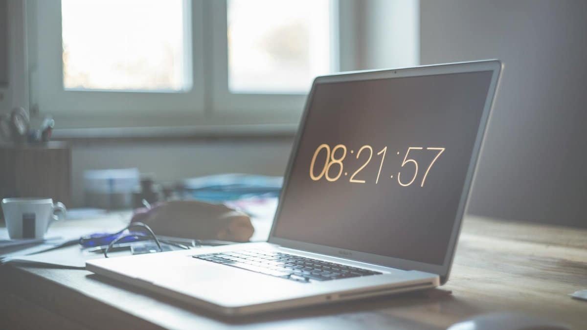 A serene workspace featuring a laptop with digital time display, perfect for productivity and focus.