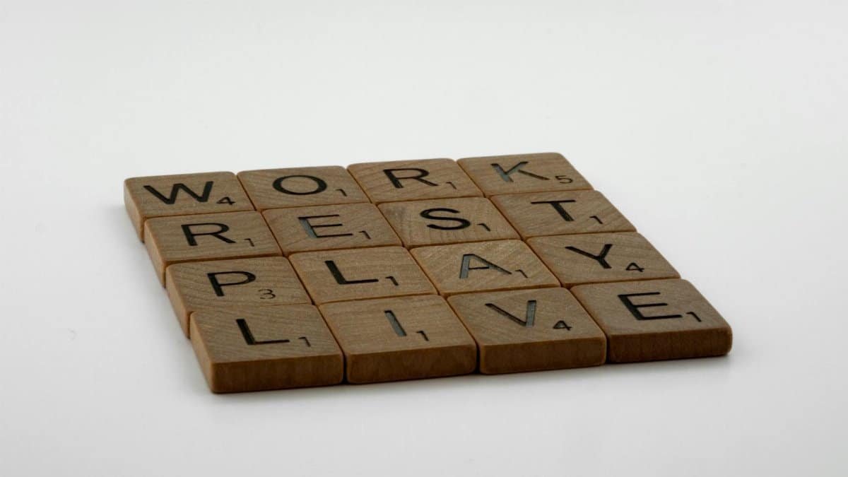 Scrabble tiles spelling work, rest, play, live emphasize life balance and priorities.