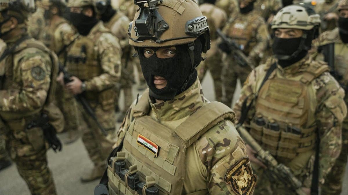 Group of soldiers in full combat gear, focused and prepared for action in a military operation setting.