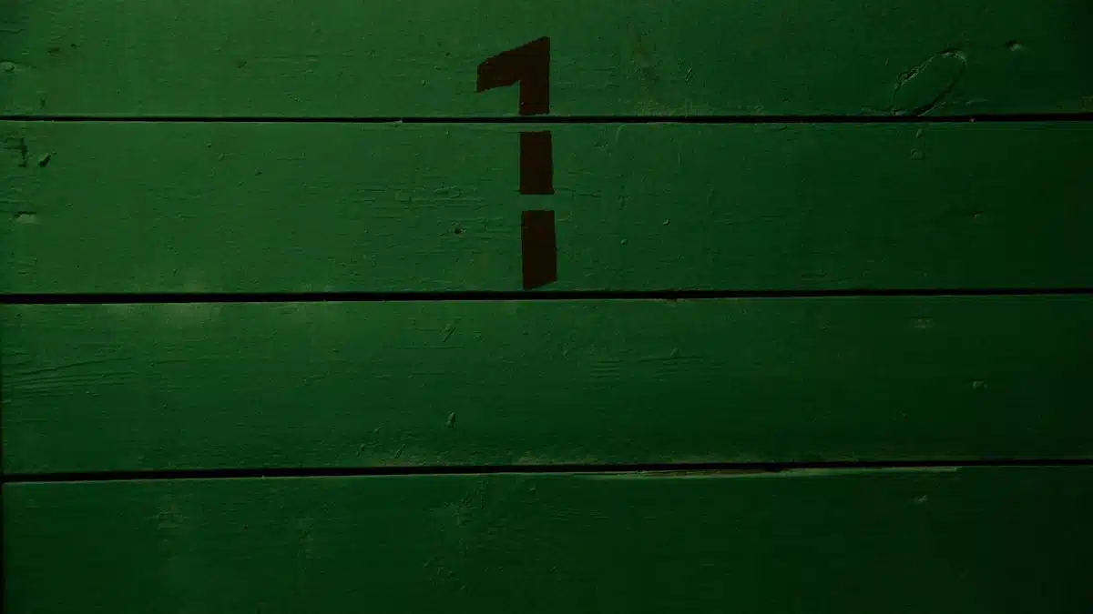 Background of plank wall of green grass color with black simple inscription representing numeral made with template