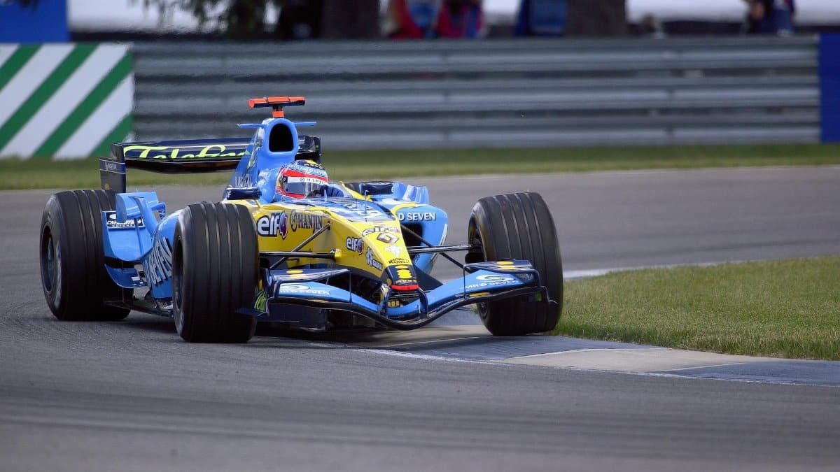 Renault F1 car speeding on Indianapolis track during championship race, showcasing high-speed performance.
