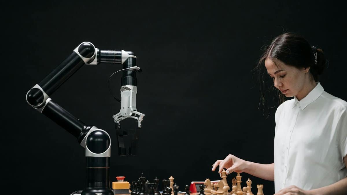 A woman plays chess against a robotic arm, showcasing AI innovation in a modern setting.