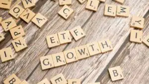 Wooden tiles spelling ETF growth on a wooden surface, symbolizing investment strategy.
