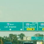 Highway signs with directions to Los Angeles, Long Beach, and Sacramento on a clear day.