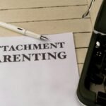 Vintage typewriter and paper with 'Attachment Parenting' text on wooden desk.