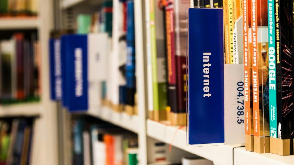 Close-up of a library shelf with books on internet and technology. Ideal for education-themed projects.