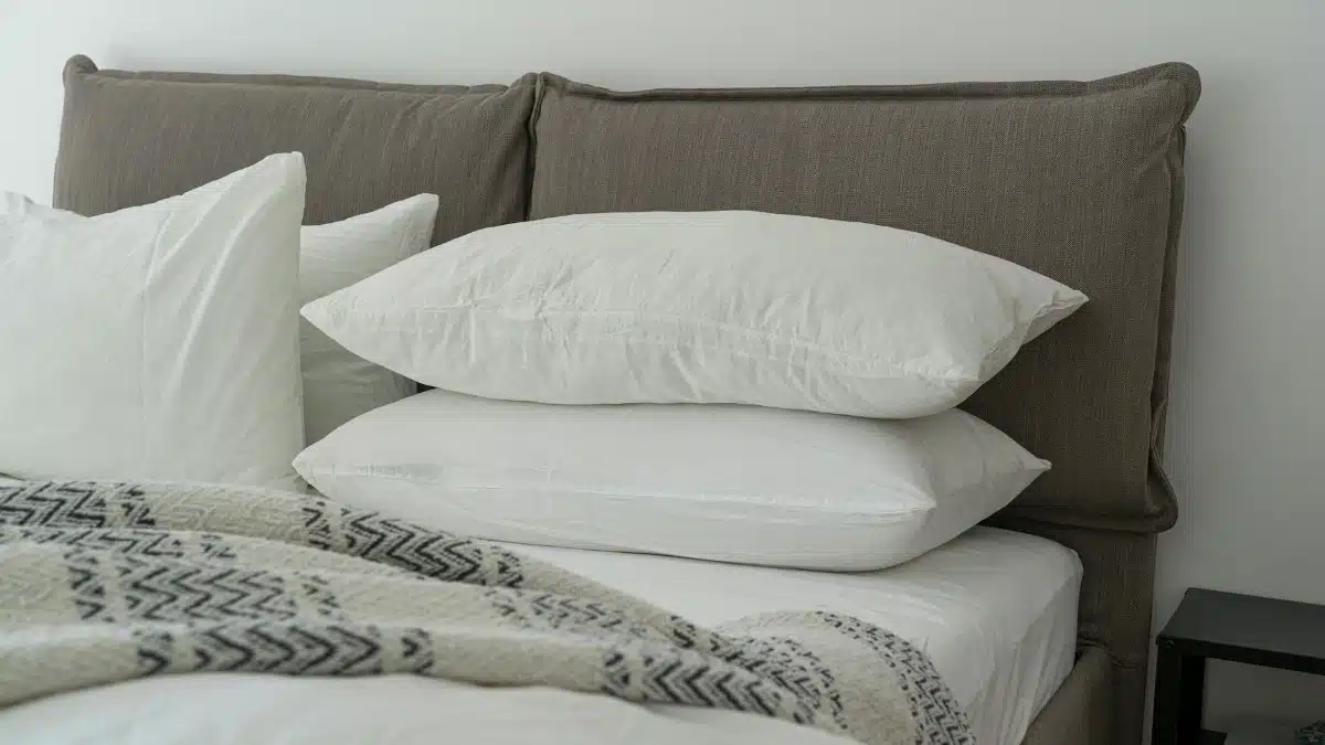 Modern bedroom featuring clean white bedding and pillows for a cozy and inviting atmosphere.