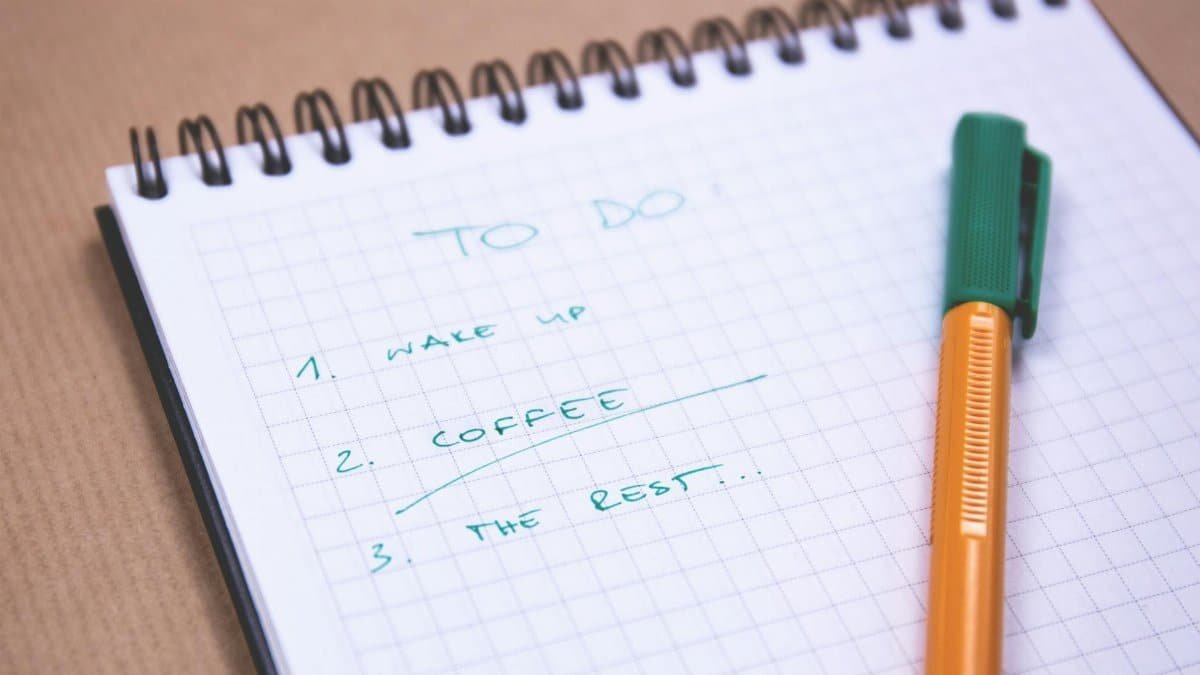 Handwritten to-do list on graph paper notebook with pen. Ideal for organizing tasks.