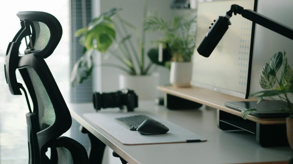 Stylish home office setup with ergonomic chair, plants, and tech accessories creating a modern work environment.
