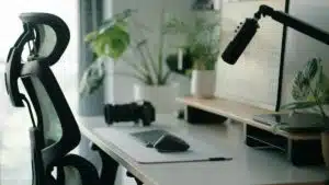 Stylish home office setup with ergonomic chair, plants, and tech accessories creating a modern work environment.