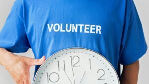 Close-up of a volunteer holding a wall clock, symbolizing time commitment.
