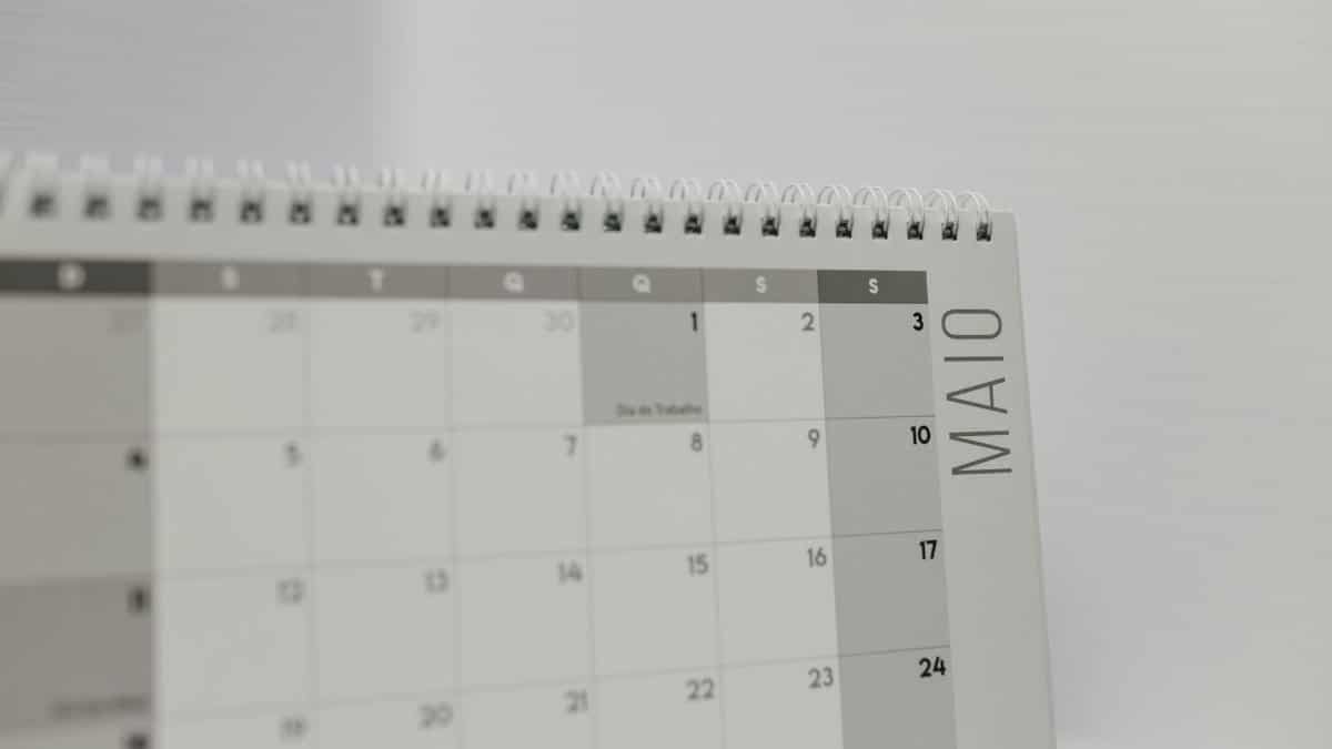 Spiral-bound calendar showing May with focus on weekdays in Portuguese.
